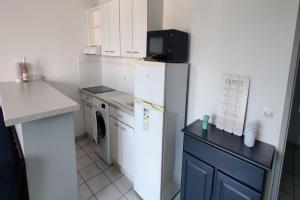 a small kitchen with a refrigerator and a microwave at Très beau T2 - Emeraude 40 in Canet-en-Roussillon