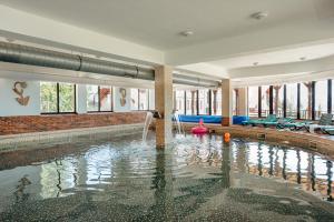 a swimming pool in a building with a swimming pool at Complex Turistic Alpina Blazna Sant in Şanţ