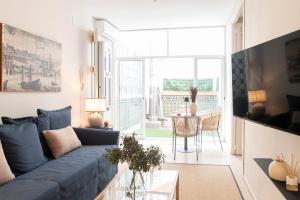 a living room with a blue couch and a table at Alohamundi Chicarreros Catedral in Seville