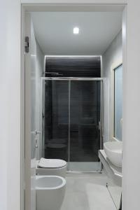 Un baño blanco con inodoro y lavabo. en Villa Sant'Anna Modern, en Aci Catena