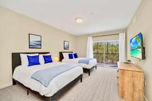 a bedroom with two beds and a balcony at Near Disney - 2BR Condo Unit - Pool and Hot Tub in Orlando