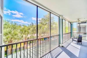 a balcony with a chair and large windows at Near Disney - 2BR Condo Unit - Pool and Hot Tub in Orlando