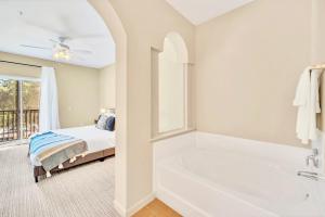 a bedroom with a bed and a bath tub next to a window at Near Disney - 2BR Condo Unit - Pool and Hot Tub in Orlando +17 photos
