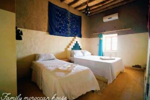 a bedroom with two beds and a window at Sahara Desert Experience camp in Merzouga
