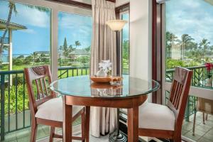 balcone con tavolo in vetro e 2 sedie di Waipouli Beach Resort F301 a Wailua