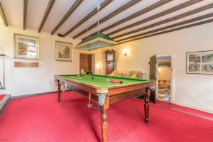 a pool table in a room with a red carpet at Bwthyn-Betws in Dolbenmaen
