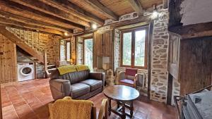 ein Wohnzimmer mit Sofa und Tisch in der Unterkunft La petite maison in Château-Chervix