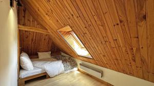 ein kleines Schlafzimmer mit einem Bett in einer Holzhütte in der Unterkunft La petite maison in Château-Chervix