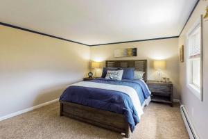 a bedroom with a bed with blue sheets and a window at The Apartment at the Compound in Fort Ann +11 photos