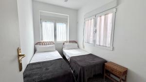 two beds in a room with two windows at Las perlas VYBDenia in Denia