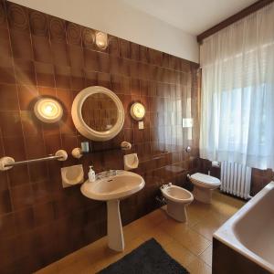 a bathroom with a sink and a toilet and a mirror at Casa Eliana Mountain Lake Iseo Hospitality in Sovere