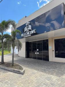 カルダス・ノバスにあるApartamentos The Villeneuve Residenceの前にヤシの木がある建物