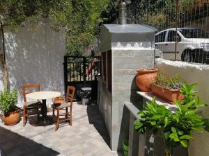 a patio with a table and chairs and plants at Eleni's Traditional Home with Barbeque in Zaros