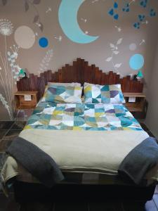 a bedroom with a bed with a colorful quilt at Dreams in Vryheid