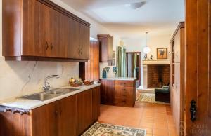 a kitchen with wooden cabinets and a sink at Quinta da Atela in Alpiarça