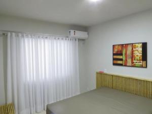 カルダス・ノバスにあるApartamentos The Villeneuve Residenceのベッドと白いカーテンが備わる部屋 +37枚の写真