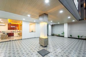 a lobby with a pillar in the middle of a room at Basotel Hotel Indore Vijaynagar in Indore