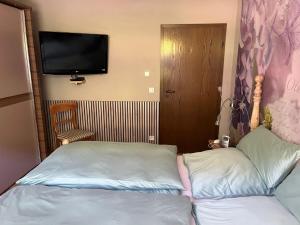 a bedroom with a bed and a flat screen tv at Ferienwohnung Weirich in Moselkern
