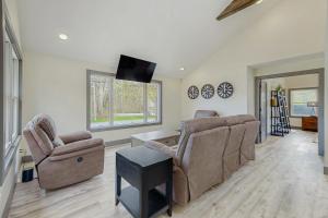 a living room with two chairs and a flat screen tv at The House at the Compound in Fort Ann