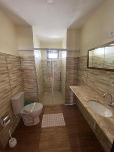 un bagno con wc, lavandino e doccia di Residência Europa a Luis Correia