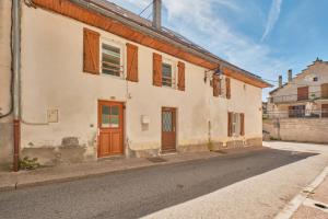 an old house with wooden doors on a street at Grande Maison De Ville Renove in Villard-de-Lans