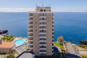 an apartment building with the ocean in the background at Duas Torres Hotel in Funchal