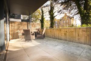 a patio with a table and chairs and a fence at Secluded two bedroom apartment in Padstow