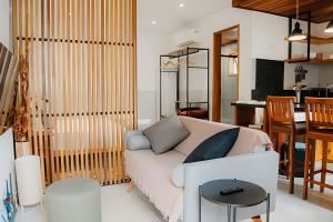 een woonkamer met een witte bank en een tafel bij Vila Trancoso Perequê in Ilhabela