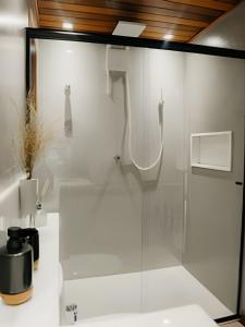 een glazen douche in een badkamer met een wastafel bij Vila Trancoso Perequê in Ilhabela +50 foto's