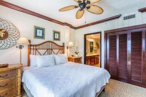 una camera da letto con un letto e un ventilatore a soffitto di Waipouli Beach Resort F201 a Wailua Altre 26 foto