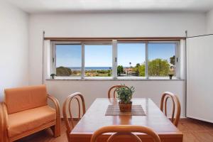 une salle à manger avec une table et des chaises et une fenêtre dans l'établissement Sea and Sky, à Vila Nova De Cacela