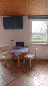 une pièce avec une table et deux chaises et une fenêtre dans l'établissement FeWo Nr 1 - 4-Personen, à Schlagsdorf
