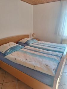 - un lit avec une couverture bleue et blanche dans l'établissement Bauernhof Urlaub FeWo Nr 2 - 2-Personen, à Schlagsdorf