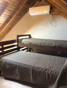a bedroom with two beds and a air conditioner on the wall at Valeria Beach in Valeria del Mar