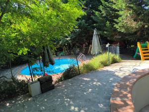 a swimming pool with a playground and an umbrella at Tamerici House in Montecastrilli