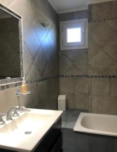 a bathroom with a sink and a tub and a window at Valeria Beach in Valeria del Mar