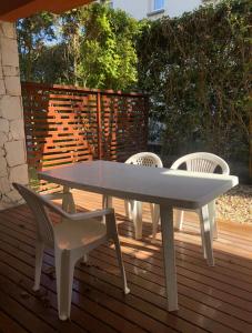 a white table and chairs on a wooden deck at Valeria Beach in Valeria del Mar