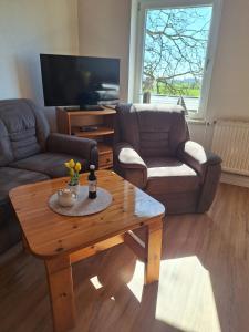 a living room with a coffee table and a couch at Bauernhof Urlaub FeWo Nr 3 - 5-Personen in Schlagsdorf