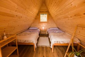 a room with two beds in a log cabin at Komac Apartma & Glamping BLED in Bled