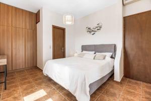 a bedroom with a large white bed and wooden cabinets at Villa Meli in Methoni +36 photos