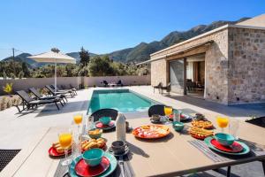 un tavolo con del cibo sopra accanto a una piscina di Villa Anthelia by Villa Plus a Palaiokatoúna