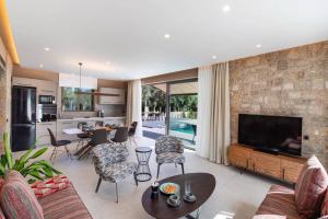 un soggiorno con TV e un soggiorno con camino di Villa Anthelia by Villa Plus a Palaiokatoúna
