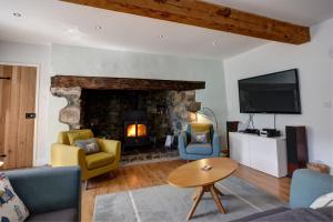 a living room with a fireplace and a tv at The Farmhouse Llyn Peninsula in Pistyll