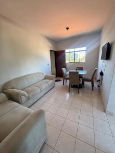a living room with couches and a dining room table at Apartamento Essenza in Gurupi