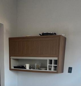 a brown cabinet with a pot on top of it at Apartamento No Centro de Gurupi Essenza in Gurupi +5 photos