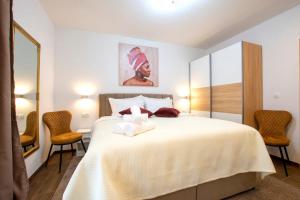 a bedroom with a large white bed with two chairs at Lux rooms Split in Split