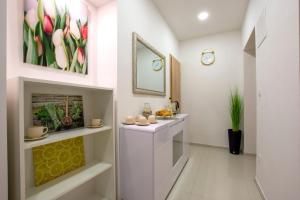 a white bathroom with a flower painting on the wall at Lux rooms Split in Split