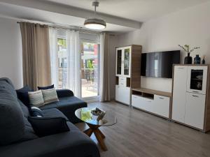 a living room with a blue couch and a tv at Apartamento Playa Granada Golf in Motril