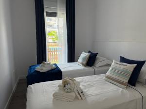 a room with three beds with towels and a window at Apartamento Playa Granada Golf in Motril +48 photos