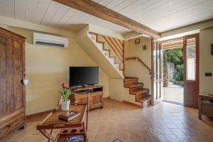 a living room with a tv and a staircase at Villa Mimì between Sorrento and Positano in Massa Lubrense